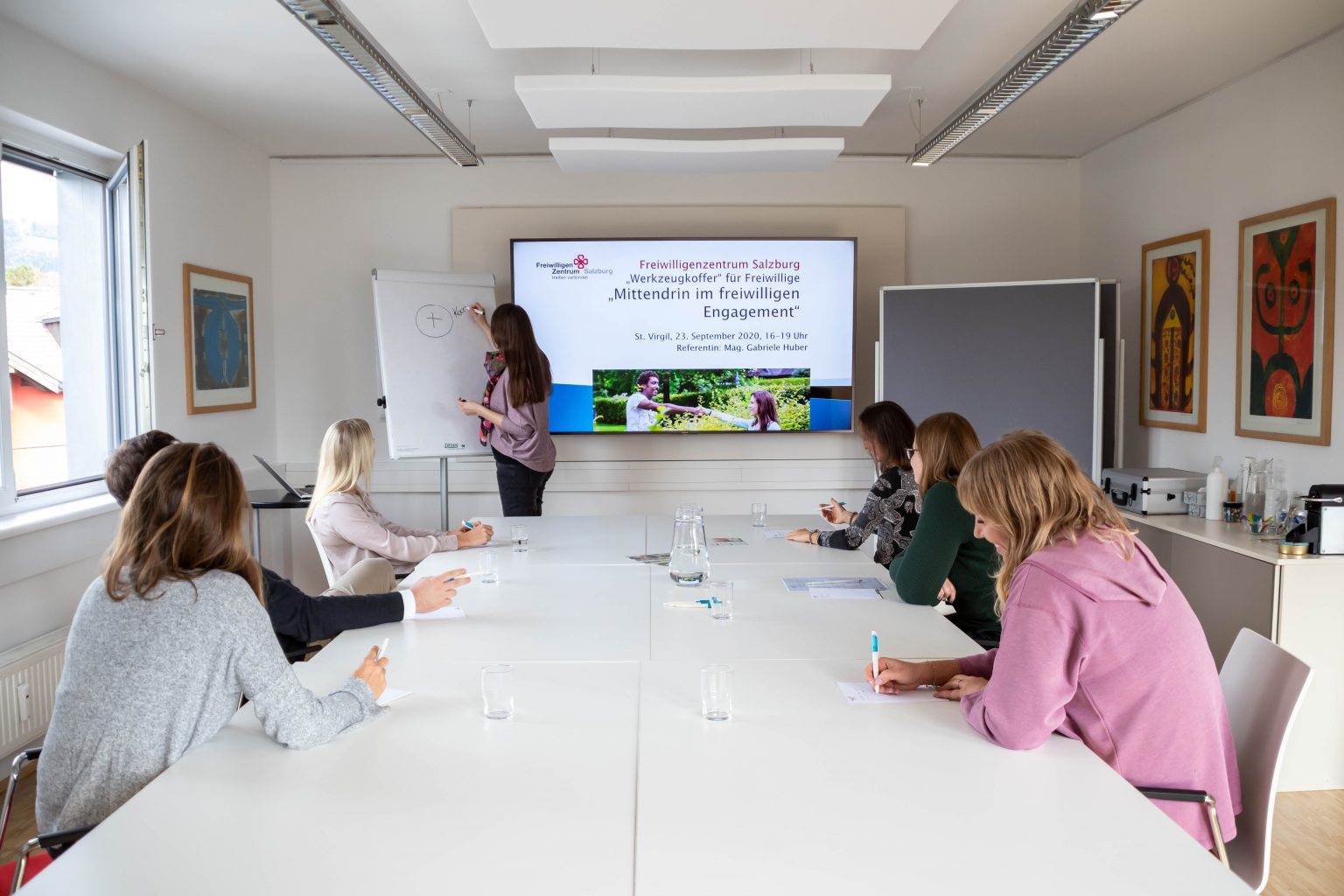 Personen sitzen bei einem Workshop, besprechen Tätigkeiten des Freiwilligenzentrum Salzburg